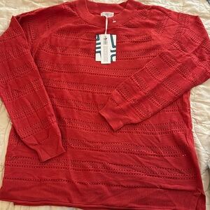 Coral crewneck sweater with detail pattern.